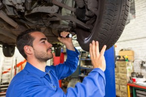 View of a Young attractive mechanic working on a car at the garage